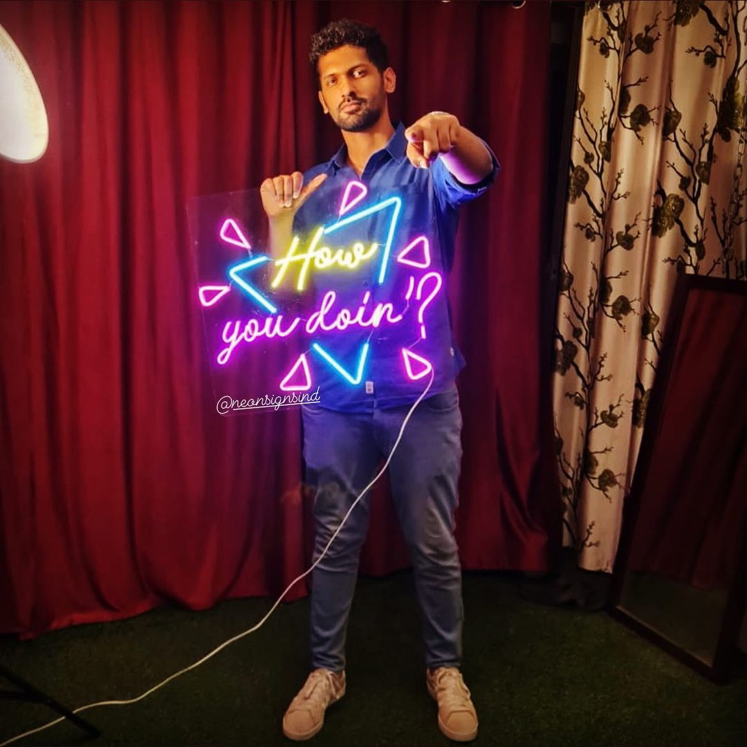 Influencer holding How You Doin neon sign