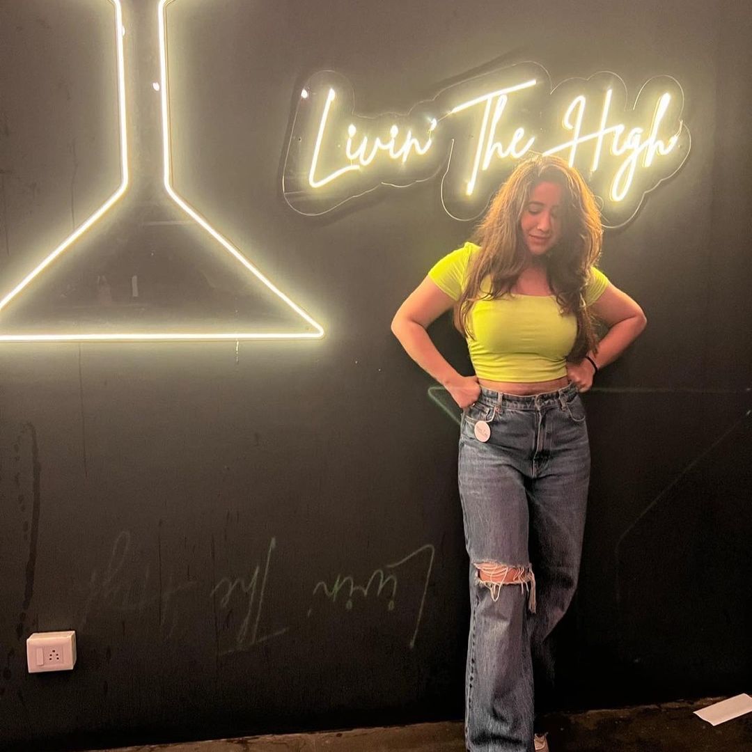 Influencer next to Livin The High neon sign